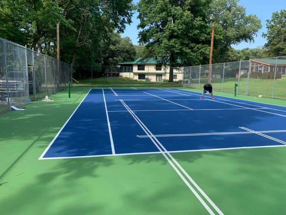 Pro Track and Tennis expert performing a site assessment to inspect the court’s foundation and identify subsurface issues before resurfacing.