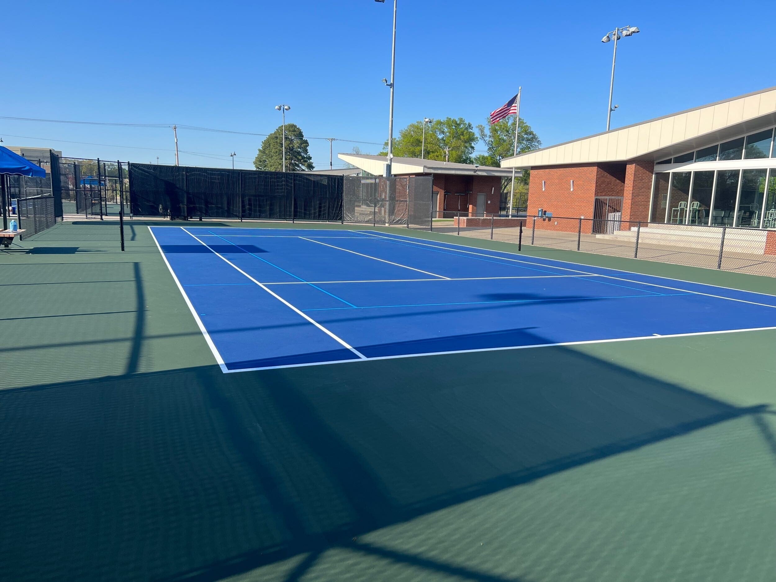 Freshly resurfaced tennis court with crisp lines and even finish.