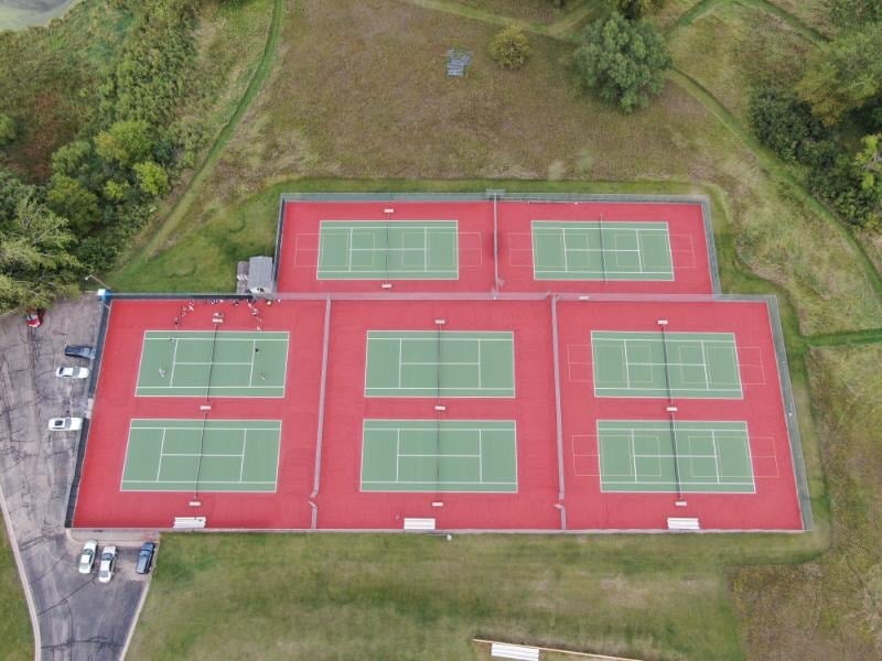 Restored tennis courts at Sauk Centre High School in Minnesota, featuring smooth, crack-free surfaces after winter damage repairs and full resurfacing by Pro Track and Tennis