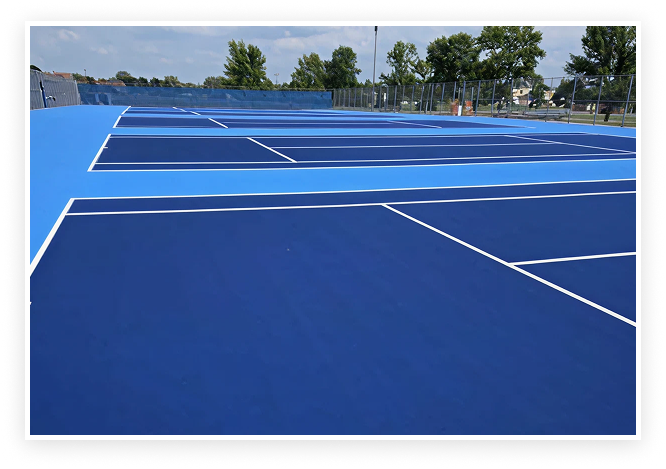 Resurfaced multi-court tennis facility with dark blue playing areas and light blue perimeter acrylic surface