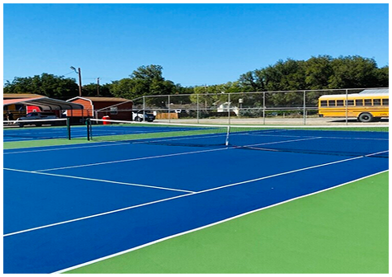 Resurfaced school tennis courts with blue acrylic playing surface and green perimeter