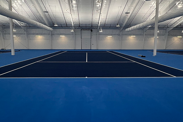 Newly surfaced indoor tennis courts in South Sioux City, NE, featuring a vibrant, cushioned playing surface
