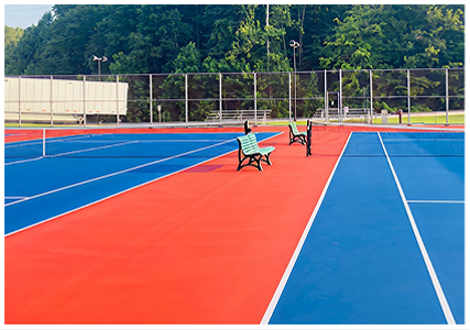 Resurfaced tennis courts in Evansville, Illinois with red and blue acrylic surface