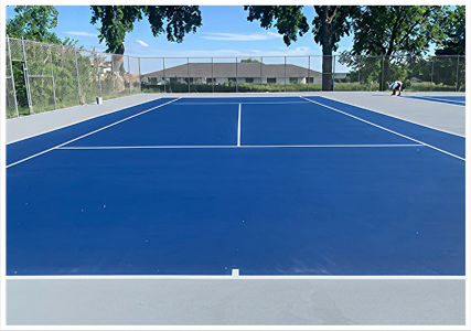 Resurfaced tennis courts in Kearney, Nebraska with blue playing area and gray perimeter
