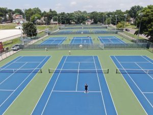 Aerial view of multiple country club tennis courts after renovation planning.