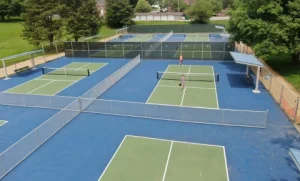 Aerial view of multiple resurfaced tennis courts with blue and green playing surfaces.