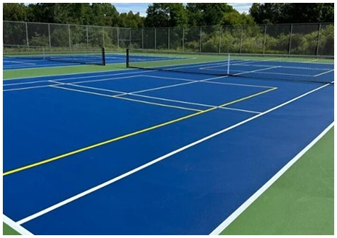 Blue and green outdoor pickleball courts with dual tennis and pickleball line markings and nets installed
