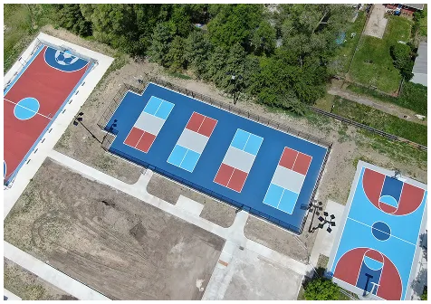Aerial view of blue and red multi-purpose courts with newly resurfaced areas for basketball and pickleball