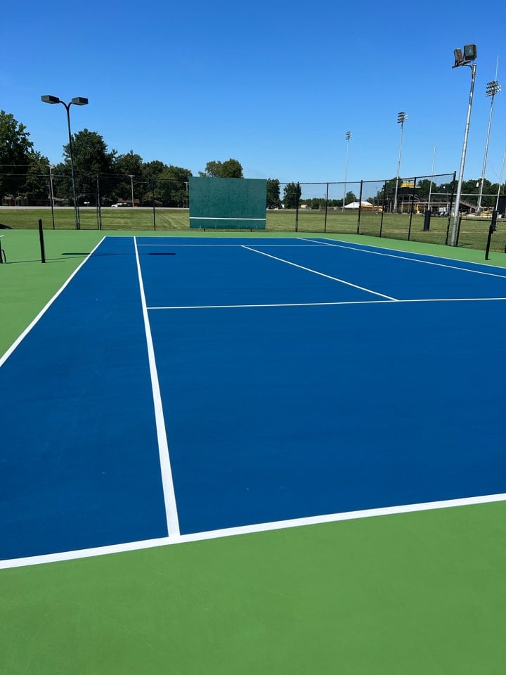Finished tennis court resurfaced for smooth play and proper drainage.