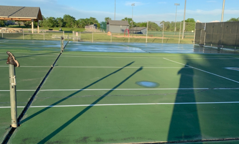 PTT WP Featured Image (9) Tennis court with standing water and surface birdbaths showing drainage issues before repair.