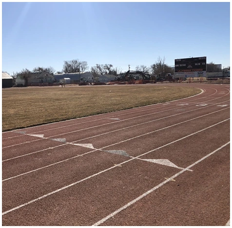 Worn running track in Georgia showing faded lanes and surface wear before resurfacing and repair.