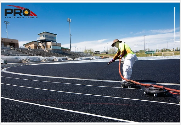 Running track resurfacing in progress with a contractor using specialized tools.
