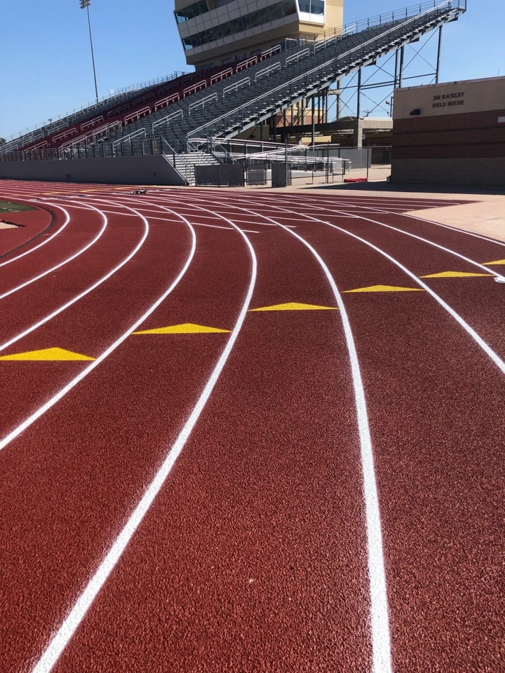 High-quality running track surface with curved lanes and relay zone markers installed by experienced contractors.