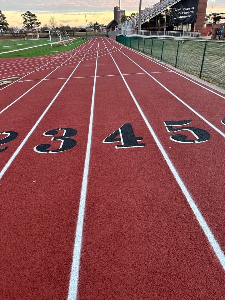 High school running track straightaway with numbered lanes on a standard 400-meter track.