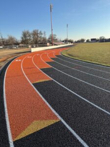 Outdoor running track with colored lane surface for maintenance and warranty planning.