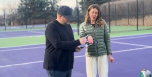 Tennis court renovation consultation with facility staff reviewing court conditions.