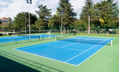 Municipal Tennis Court Grants and Funding Opportunities Municipal tennis courts in public park with newly resurfaced blue and green playing surface