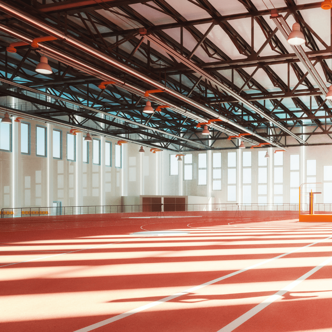 Indoor track and field facility with synthetic running track surface and structural roof framing