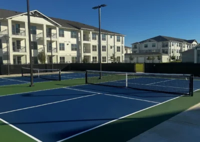Finished outdoor pickleball courts at a Baytown, Texas residential development featuring acrylic sport surface and court lighting