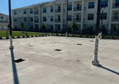Uncoated concrete court slab with net posts installed at a new residential development in Baytown, TX