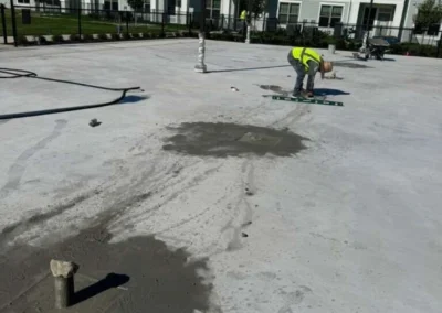 Pro Track and Tennis crew performing concrete surface preparation and leveling before pickleball court coating in Baytown, Texas