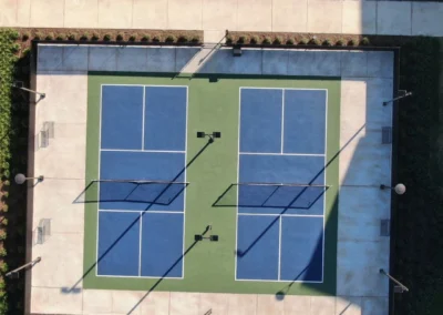 Aerial view of completed residential pickleball courts in Baytown, Texas with blue and green acrylic sport surface
