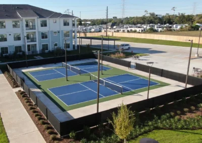 Completed outdoor pickleball courts at a residential community in Baytown, TX showing finished acrylic surface and perimeter fencing