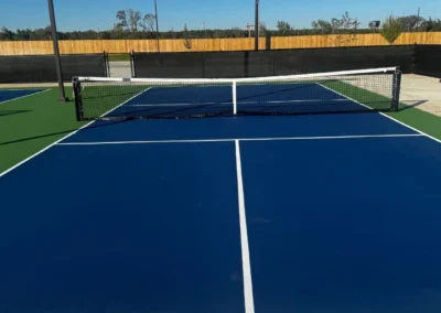 Close up of completed pickleball court surface with blue and green acrylic coating and official striping in Baytown, Texas