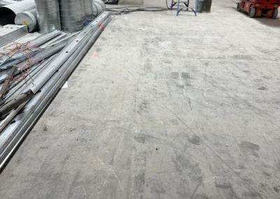 Staged HVAC ductwork and equipment on concrete subfloor during indoor tennis court facility construction