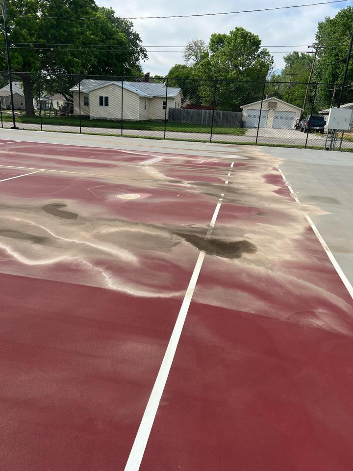 Tennis court with severe birdbaths and surface damage showing why drainage issues reduce ability to extend tennis court lifespan