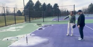 Tennis court reconstruction assessment with standing water and surface drainage issues.