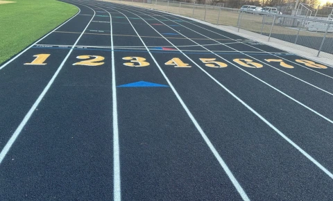 Running Track Warranty and Maintenance Planning Black running track with lane numbers and markings after warranty and maintenance planning.