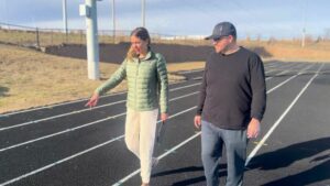 Running track project walkthrough with facility staff reviewing completed surface work.