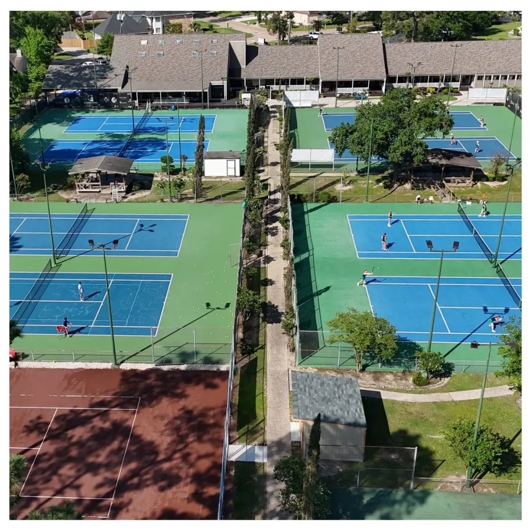 Aerial view of multiple blue and green tennis courts at Giammalva Racquet Club, with players on several courts.